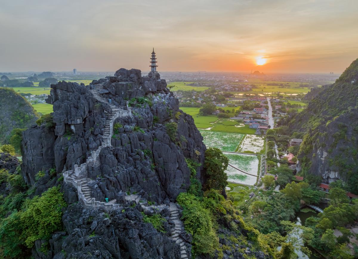Paysage spectaculaire de pitons karstiques et de rivières paisibles à Ninh Binh illustrant la parfaite étape nature de votre circuit Vietnam Cambodge Laos.