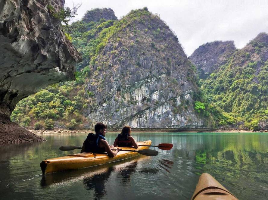 Voyageurs explorant les paysages paisibles de la baie de Lan Ha, une transition nature idéale pour votre itinéraire Vietnam Cambodge.