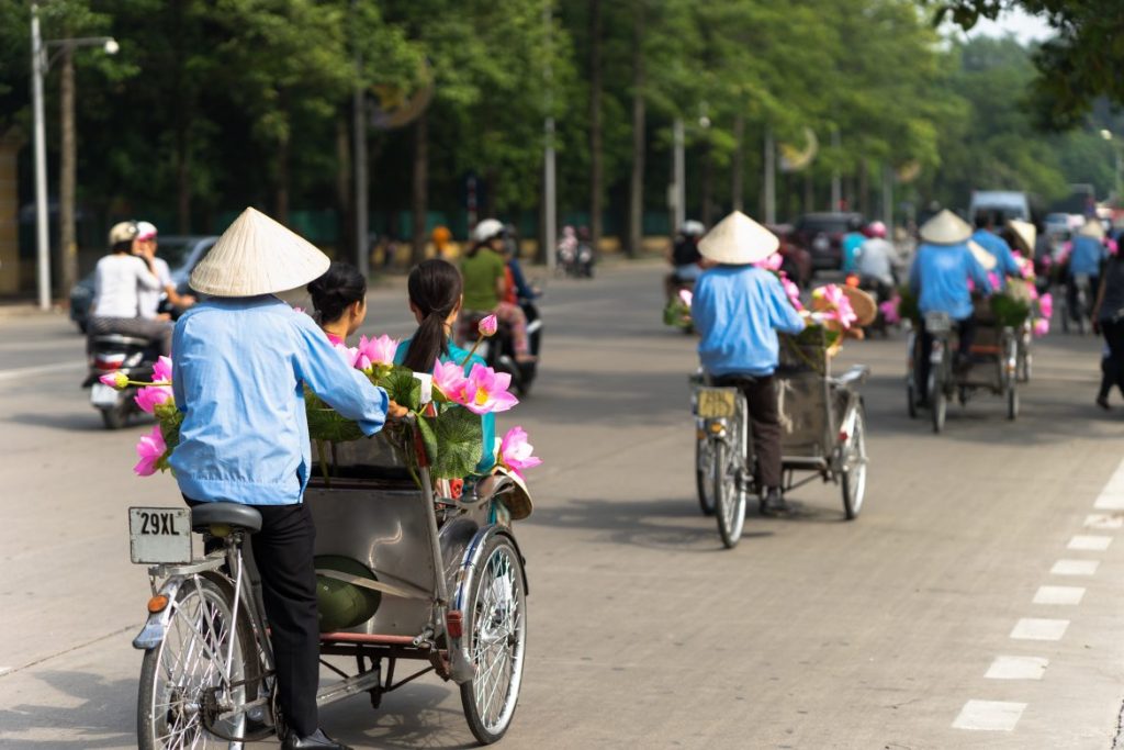 Escena matutina vibrante en las calles de Hanoi, una inmersión cultural esencial para sincronizar su reloj biológico durante un itinerario de Vietnam y Camboya en 10 días.