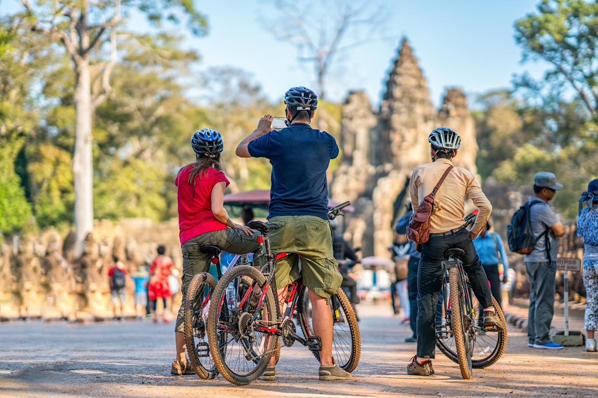 Jeunes aventuriers explorant les temples du Cambodge à vélo, une activité sur mesure parfaite pour un voyage privé Vietnam Cambodge.