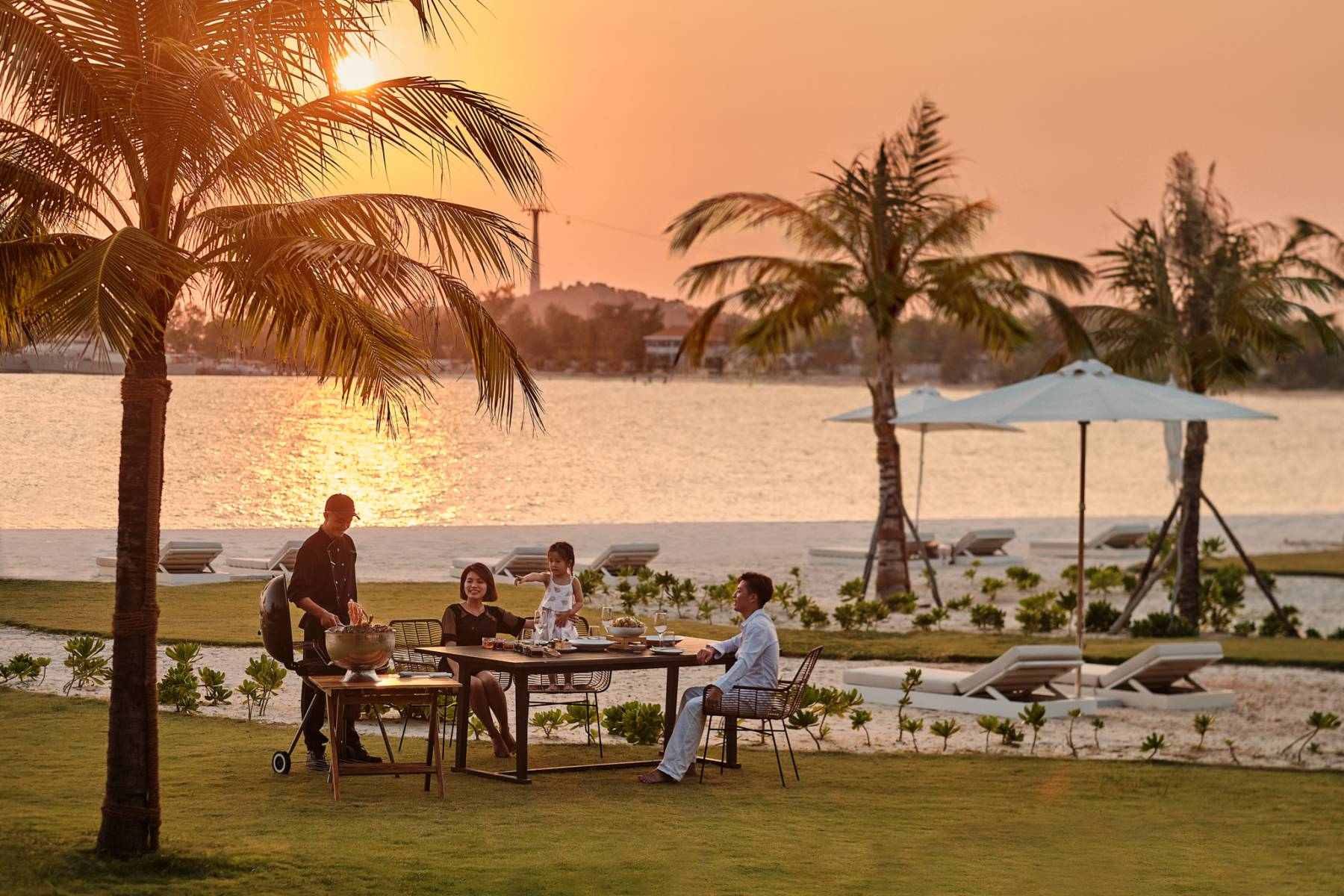 Famille savourant un dîner privé sur la plage lors d'un voyage en famille de luxe au Vietnam.