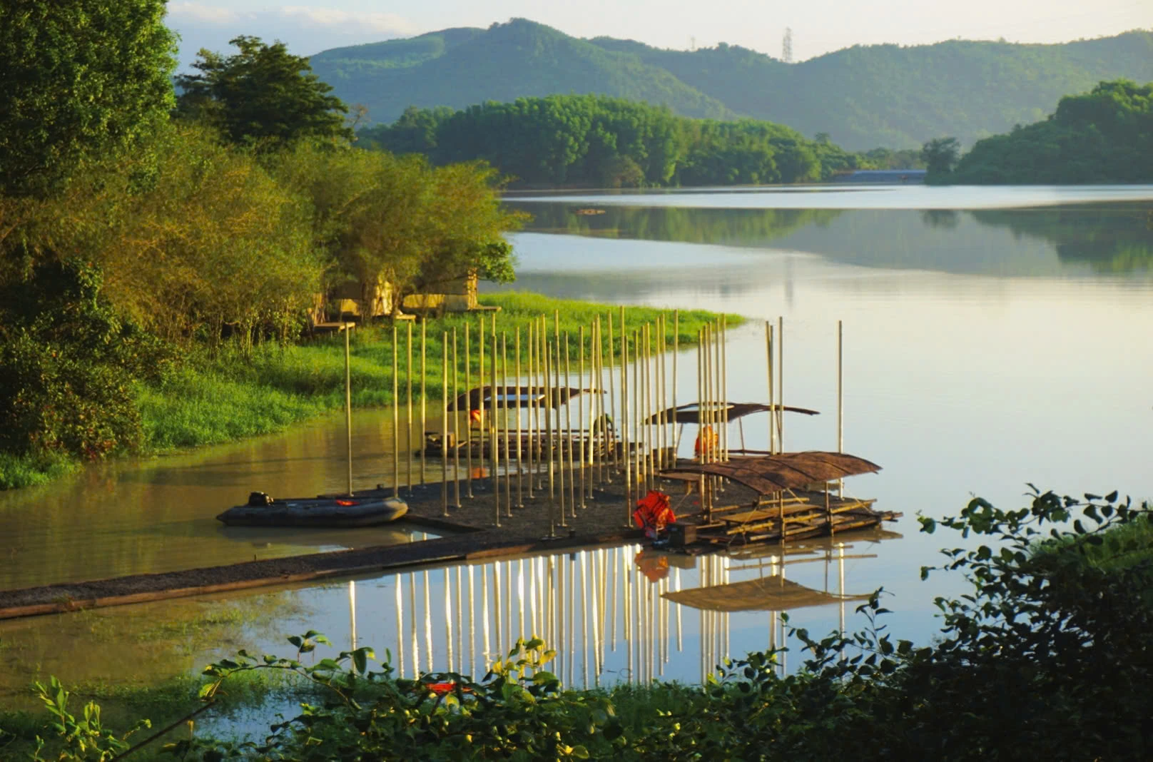 Ponton en bambou et embarcations légères au bord d'un lac paisible lors d'un voyage Vietnam en famille.