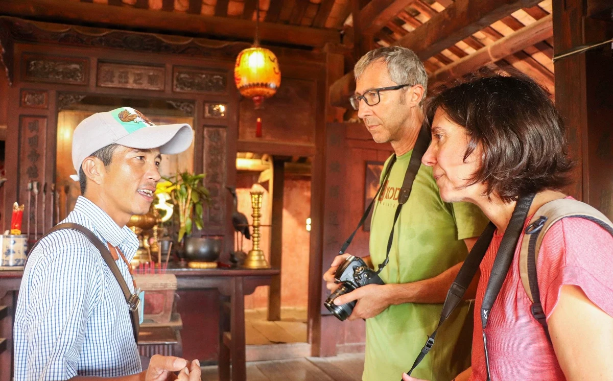 Guide local partageant l'histoire culturelle avec des voyageurs lors d'un circuit Vietnam Cambodge Laos 3 semaines