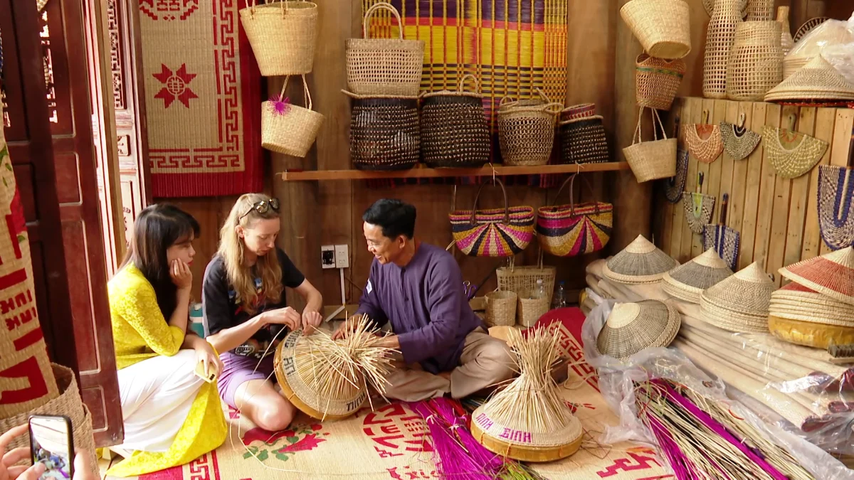 Voyageuse apprenant l'artisanat traditionnel avec un artisan local lors d'un circuit Vietnam Cambodge Laos 3 semaines
