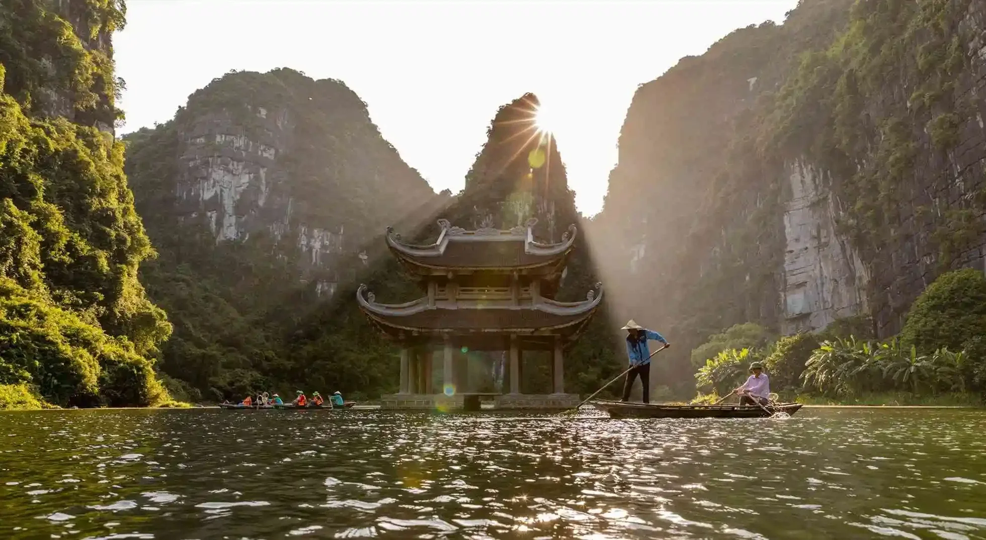 Visiter le Vietnam en 10 jours en barque traditionnelle devant le pavillon sur l'eau de Tràng An à Ninh Bình.