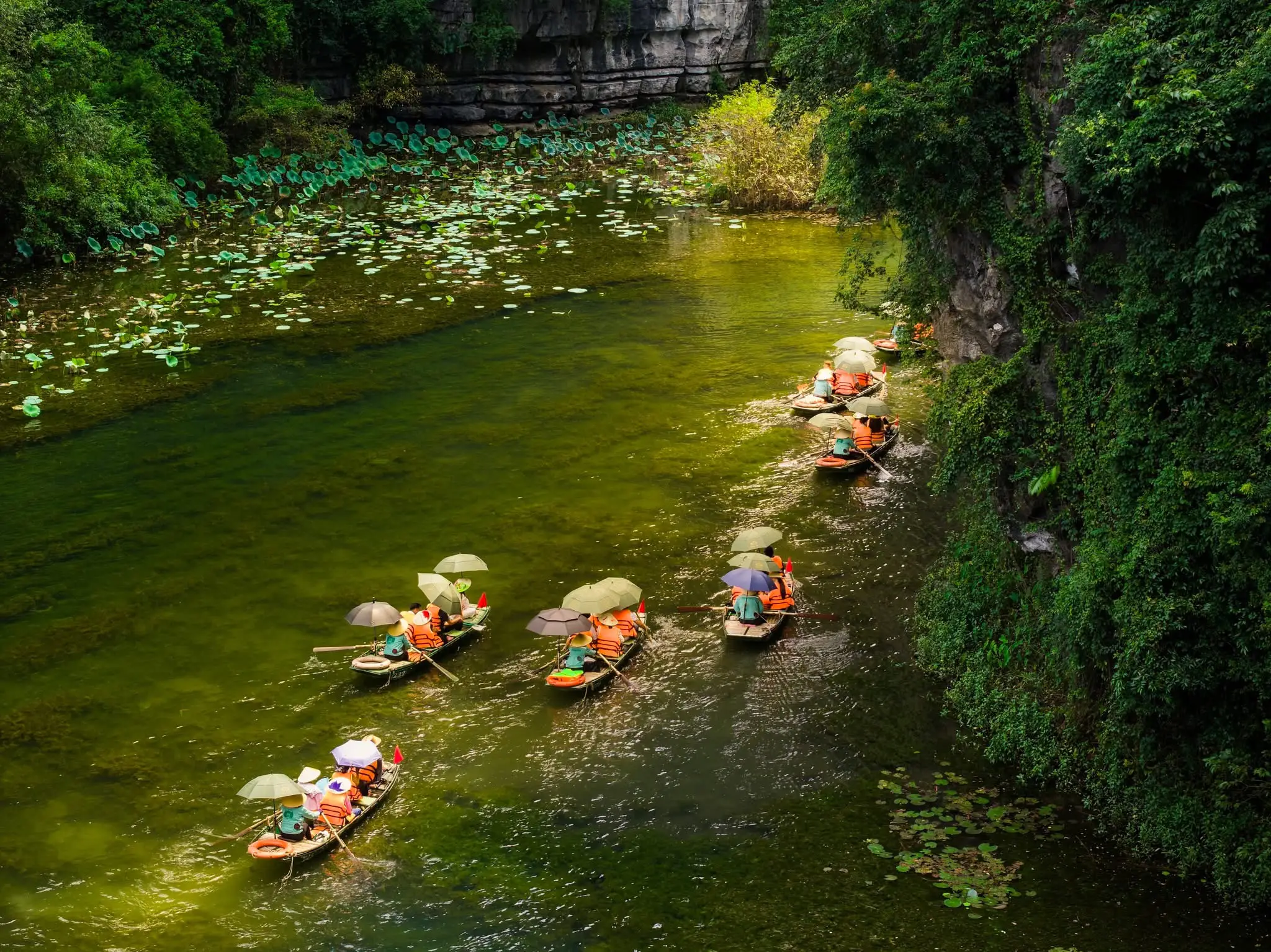 Barques traditionnelles naviguant sur les eaux cristallines de Ninh Binh lors d un voyage Vietnam 2 semaines