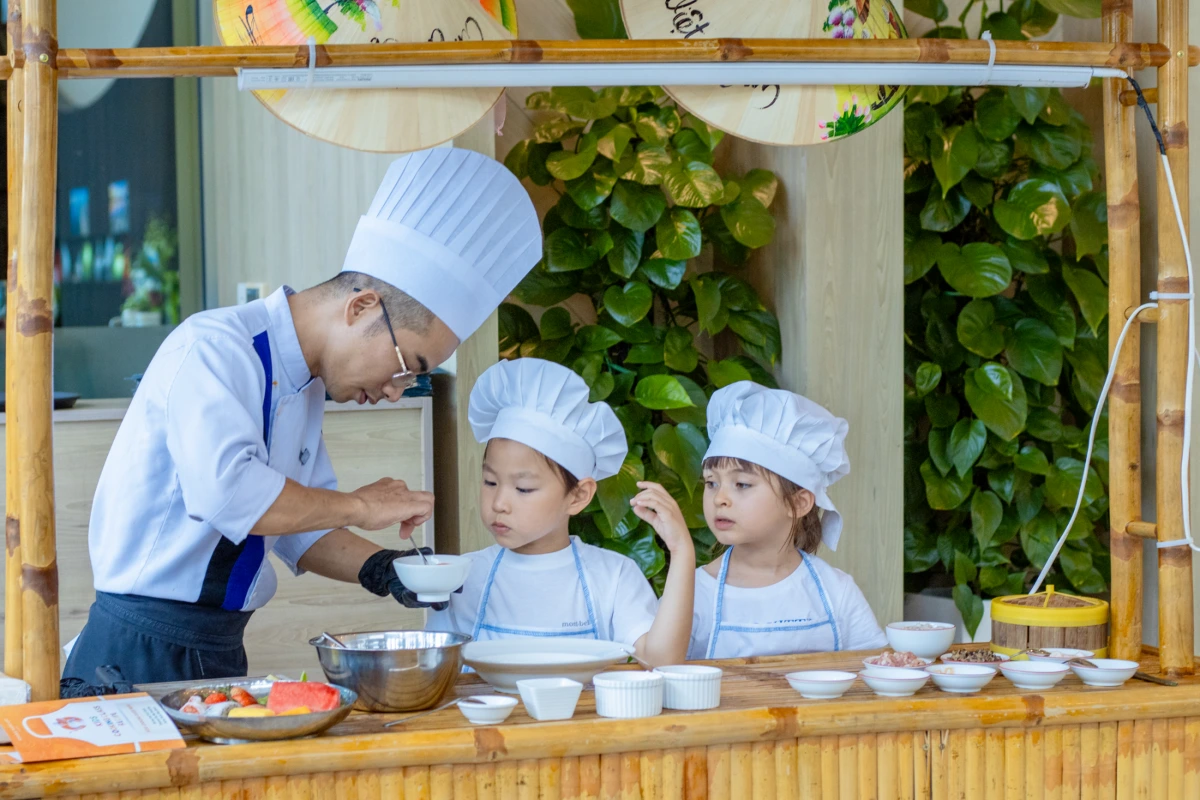 Enfants apprenant les gestes de la cuisine locale lors d'un voyage au Vietnam en famille