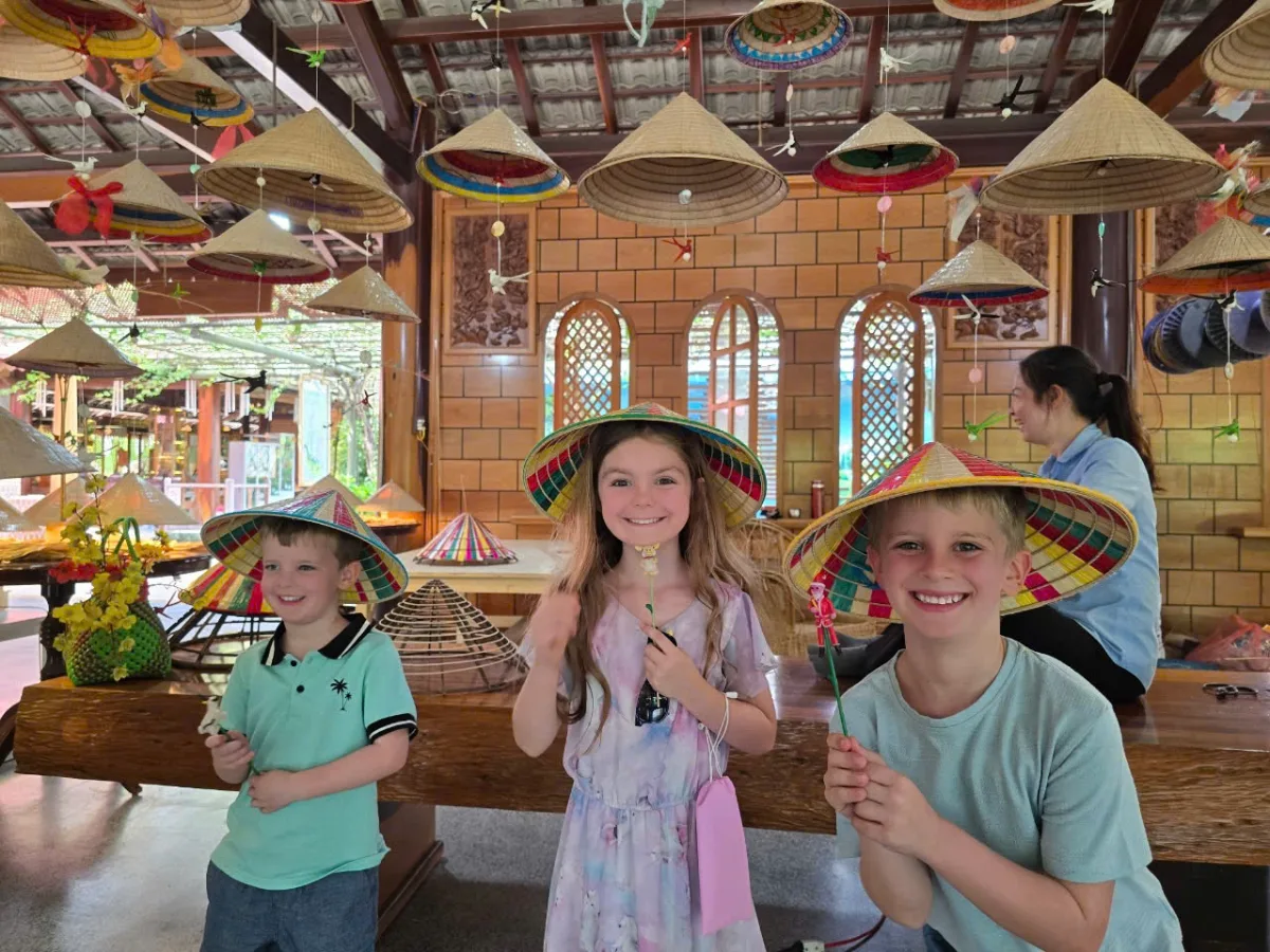 Enfants portant des chapeaux coniques personnalisés lors d'un voyage au Vietnam en famille