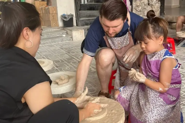 Père et fille façonnant l'argile lors d'un atelier artisanal pendant un voyage au Vietnam en famille