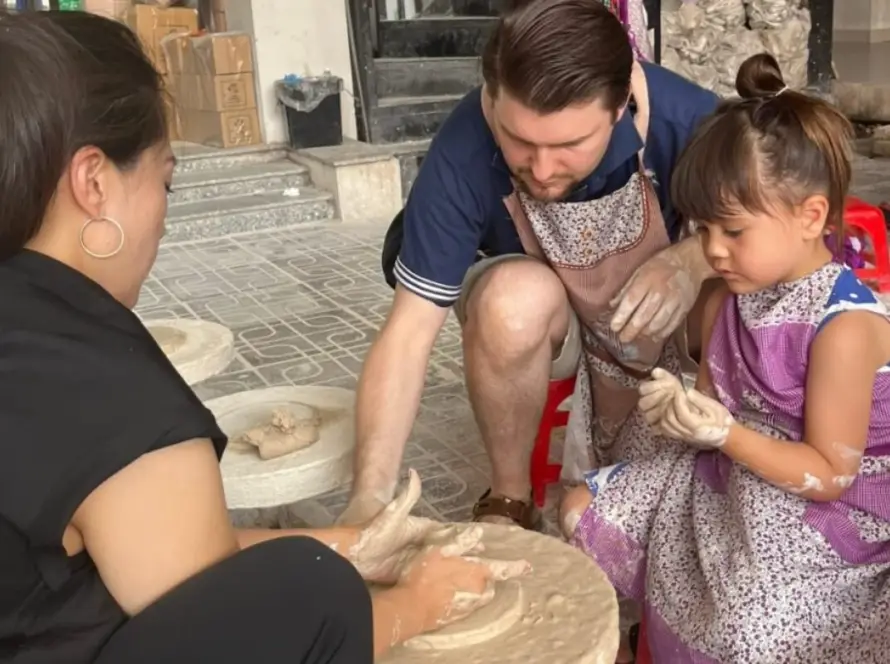 Père et fille façonnant l'argile lors d'un atelier artisanal pendant un voyage au Vietnam en famille