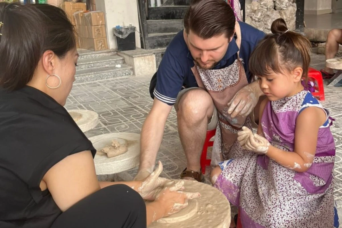 Père et fille façonnant l'argile lors d'un atelier artisanal pendant un voyage au Vietnam en famille