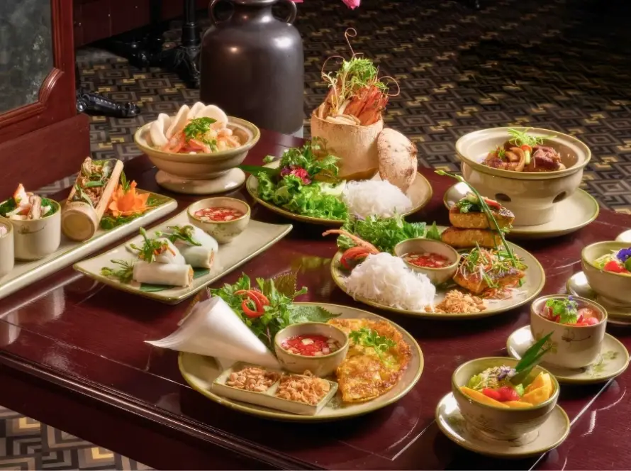 Une table raffinée de spécialités culinaires vietnamiennes dans un restaurant d'exception, illustrant le prix voyage Vietnam 12 jours